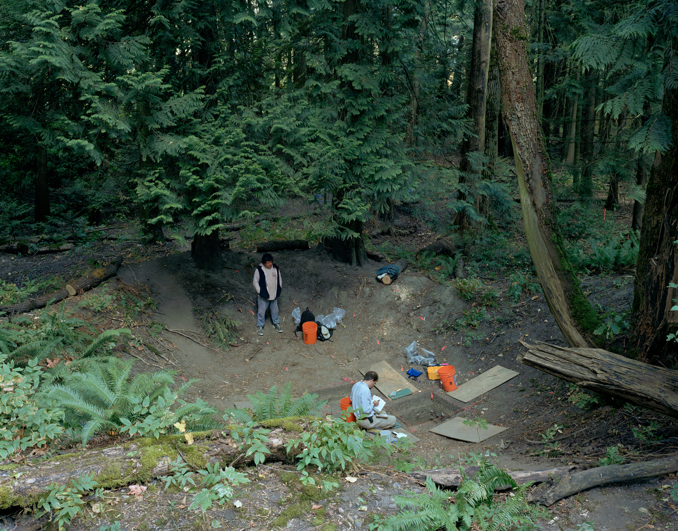 Jeff Wall - Fieldwork. Excavation of the floor of a dwelling in a former Sto:lo nation village, Greenwood Island, Hope, B.C., August 2003, Anthony Graesch, Dept. of Anthropology, University of California at Los Angeles, working with Riley Lewis of the Sto:lo band, 2003, transparency in lightbox