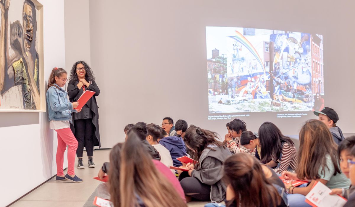 Art + Story in action. A student is reading a poem she wrote in The Broad's galleries, while her classmates look on.