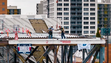 Two steelworkers shaking hands on top of the final steel beam of The Broad's expansion at the Topping Out Ceremony