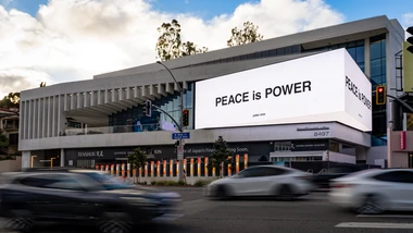 Digital billboard that reads "PEACE is POWER" by Yoko Ono