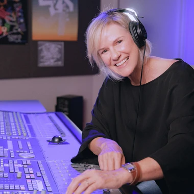 Anne Litt at a mixing console wearing headphones