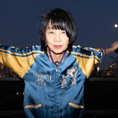 Yuka Honda photo taken during night time with flash wearing a black and yellow satin jacket