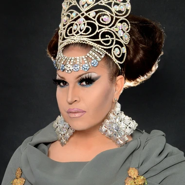 Landa Lakes in drag wearing a large tiera and ornate jewelry.