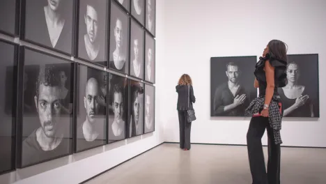 Photo of visitor looking at Shirin Neshat's works.