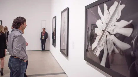 Photo of visitor looking at Shirin Neshat's work.