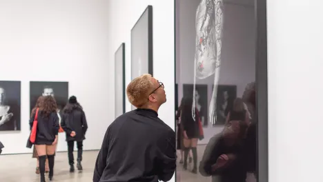 Photo of visitor looking at Shirin Neshat's work.
