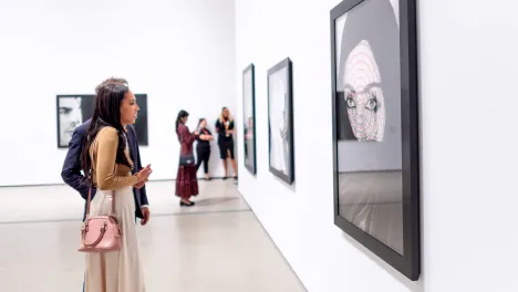 Photo of visitor looking at Shirin Neshat's work.