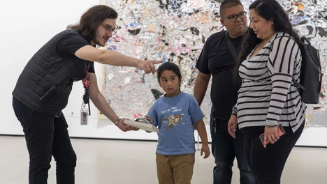 Visitor Experience Team Member speaking with visitor in the gallery