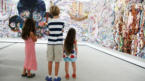 A family looks at a Takashi Murakami's painting "In the Land of the Dead, Stepping on the Tail of a Rainbow"