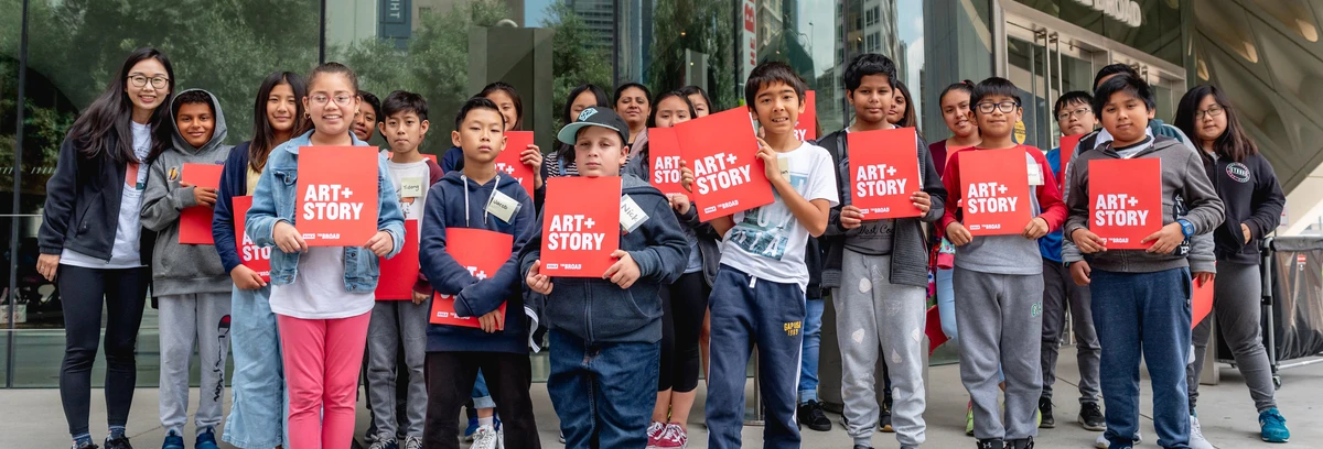 Group of students with red Art+Story folders standing in front of The Broad