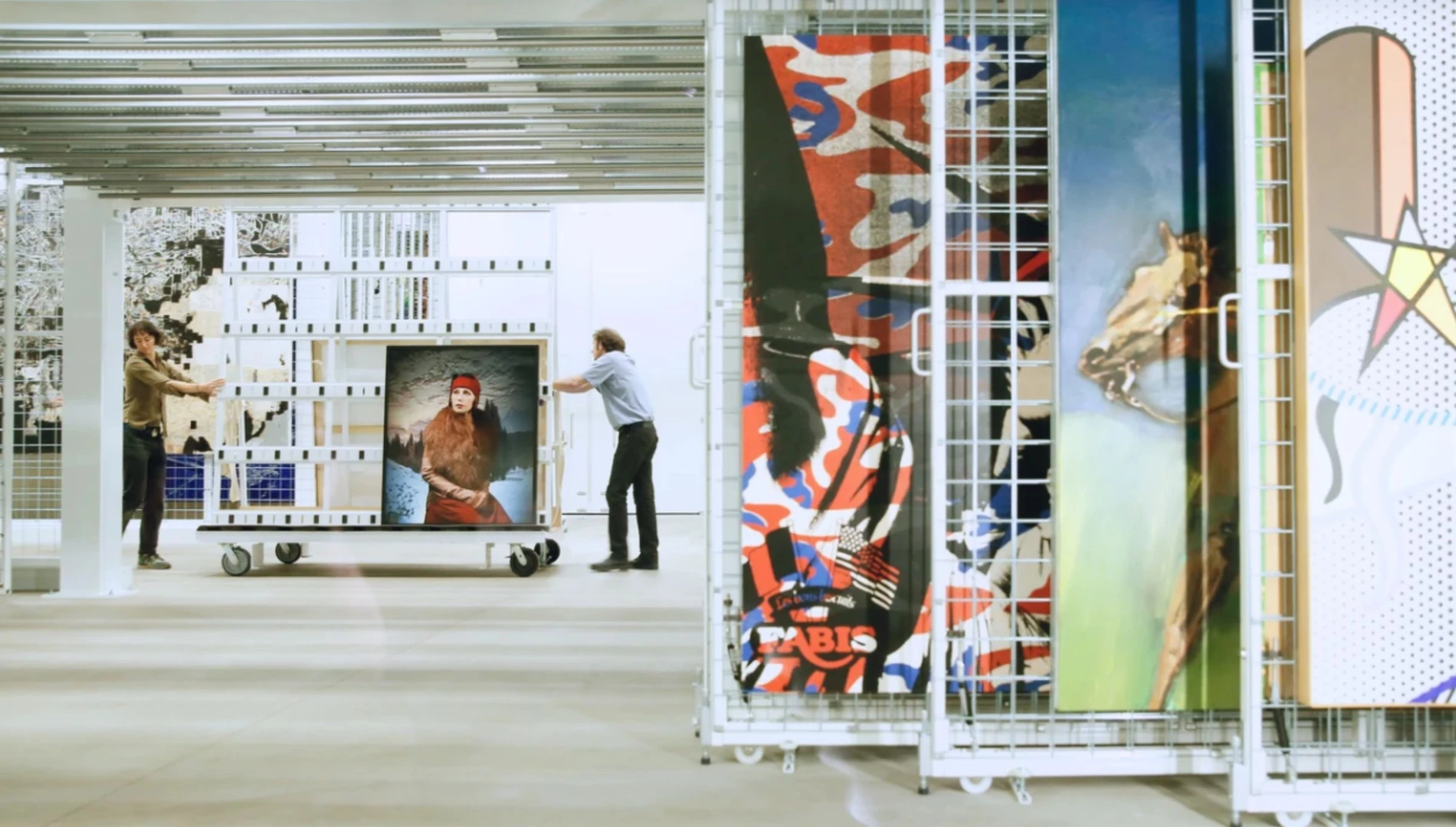 Two art preparators wheeling a Cindy Sherman artwork inside the vault at The Broad