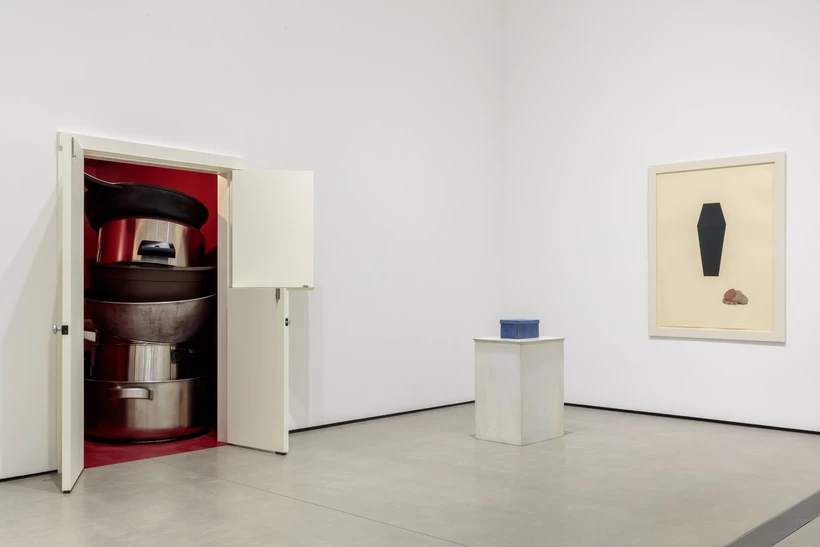 Installation image inside Robert Therrien: This is a Story, featuring a red room with oversized pots and pans