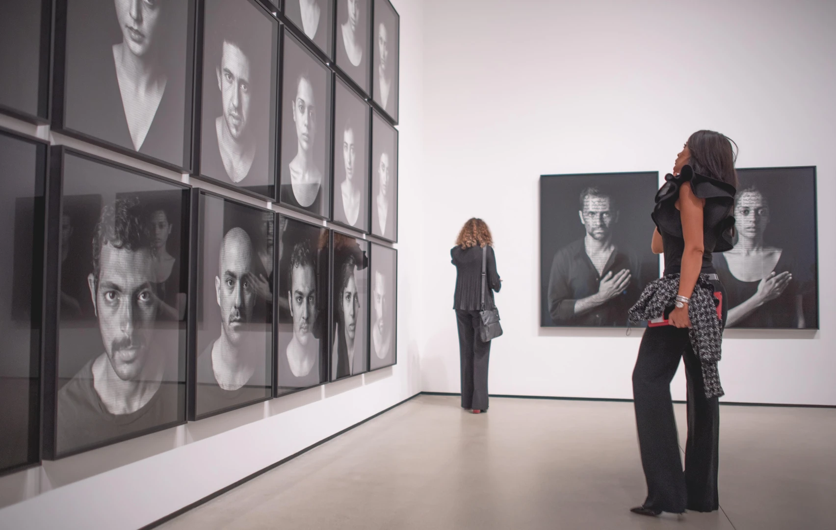 Photo of visitor looking at Shirin Neshat's works.