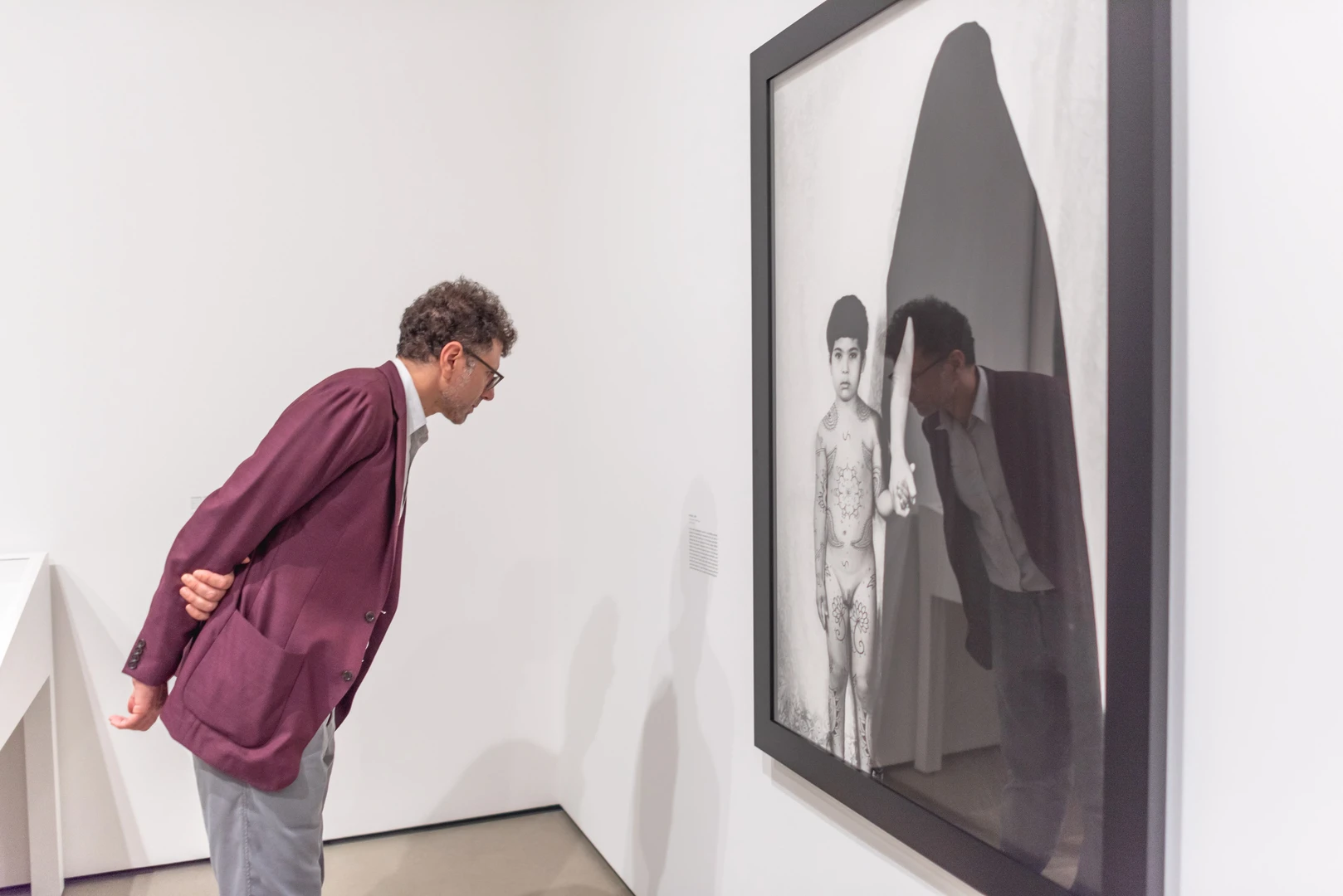 Photo of visitor looking at Shirin Neshat's work.