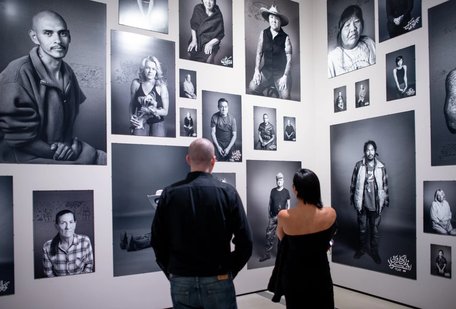 Photo of visitors looking at Shirin Neshat's work.