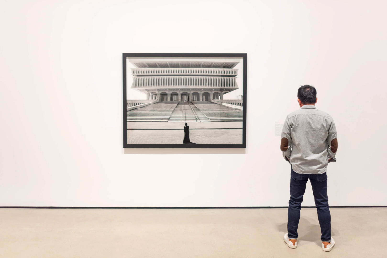 Photo of visitor looking at Shirin Neshat's work.